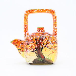 Design teapot made of clay with autumn motifs