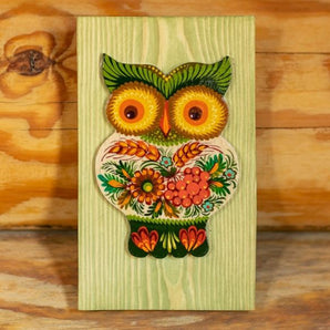 Rustic wall decoration made of wood owl on the green