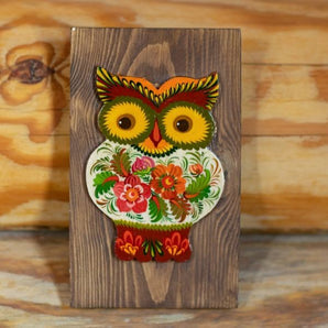 Rustic handcrafted owl wall decoration on brown wood, authentic ukrainian crafts