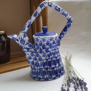 Design teapot made of clay with blue pattern