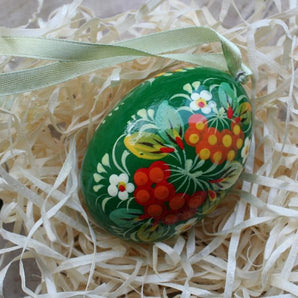 Green wooden Easter egg with traditional floral pattern