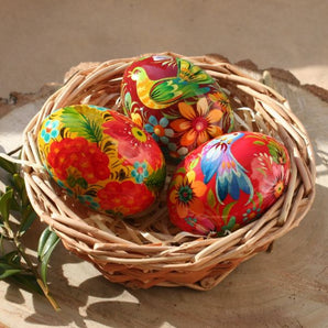 Colorful hand-painted wooden Easter eggs in a basket - Ukrainian Petrykivka painting