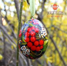 Black wooden Easter egg pysanka painted with red barries