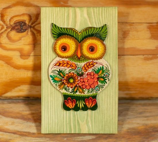 Rustic wall decoration made of wood owl on the green