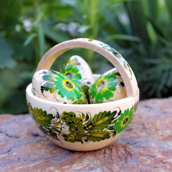 Small wooden Easter basket and Easter eggs with green floral pattern 