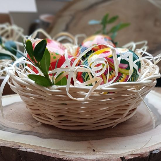 Traditional Ukrainian Easter eggs with Petrykivka painting in a basket - Easter decoration